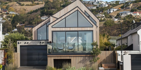 Beachville by Site Architecture, oiled cedar cladding and asymmetrical roofline set against the red cliffs of Te Raekura Christchurch.