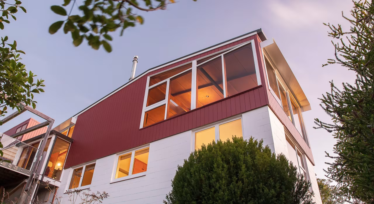 <img alt="Exterior of Hillside Modern, warm light glowing through large windows, red and white facade set among mature trees." src="/images/s/i/t/e/-/site-architects-interior-architecture-modernist6-00031c95.webp" width="2560" height="1707" />